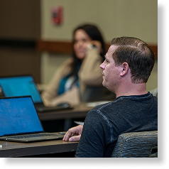Male attendee listening during an educational session at IFMA’s Facility Fusion Conference, representing professional growth and learning.